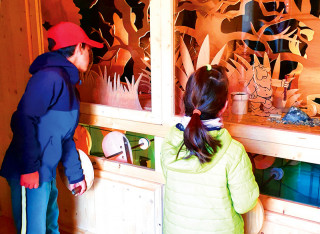 Des enfants regardant une vitrine de la Magie des Automates