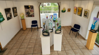 Salle d'exposition accueillant une exposition de peinture sur vitrail