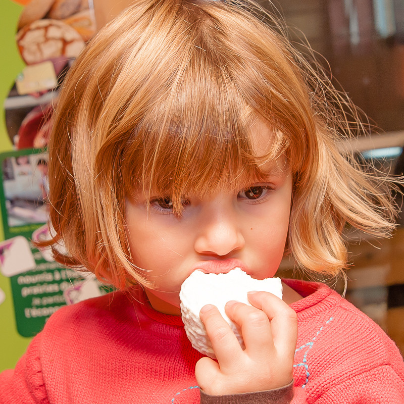 Jeune fille mangeant un fromage de chèvre frais