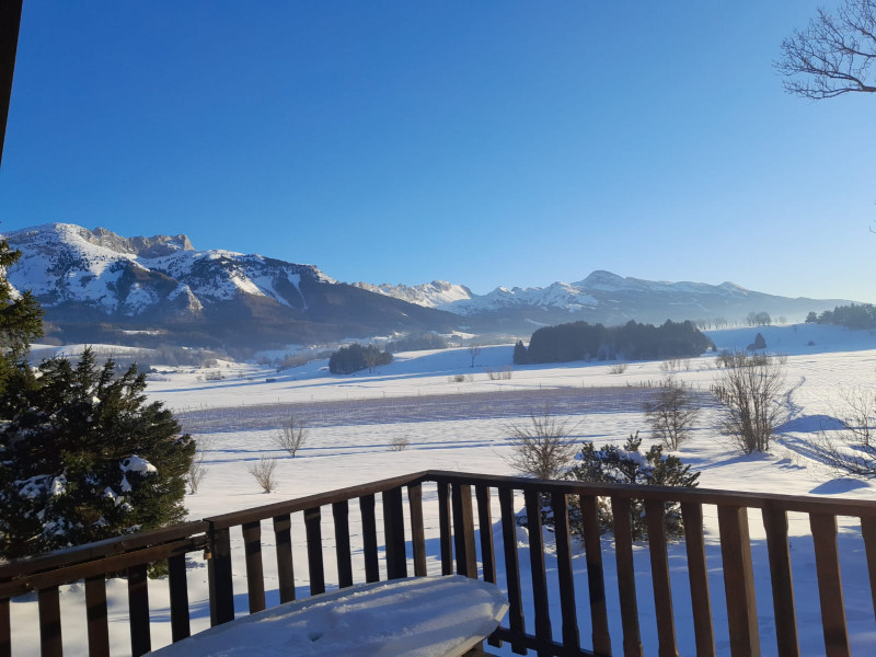 Terrasse enneigée du chalet avec vue sur les montagnes